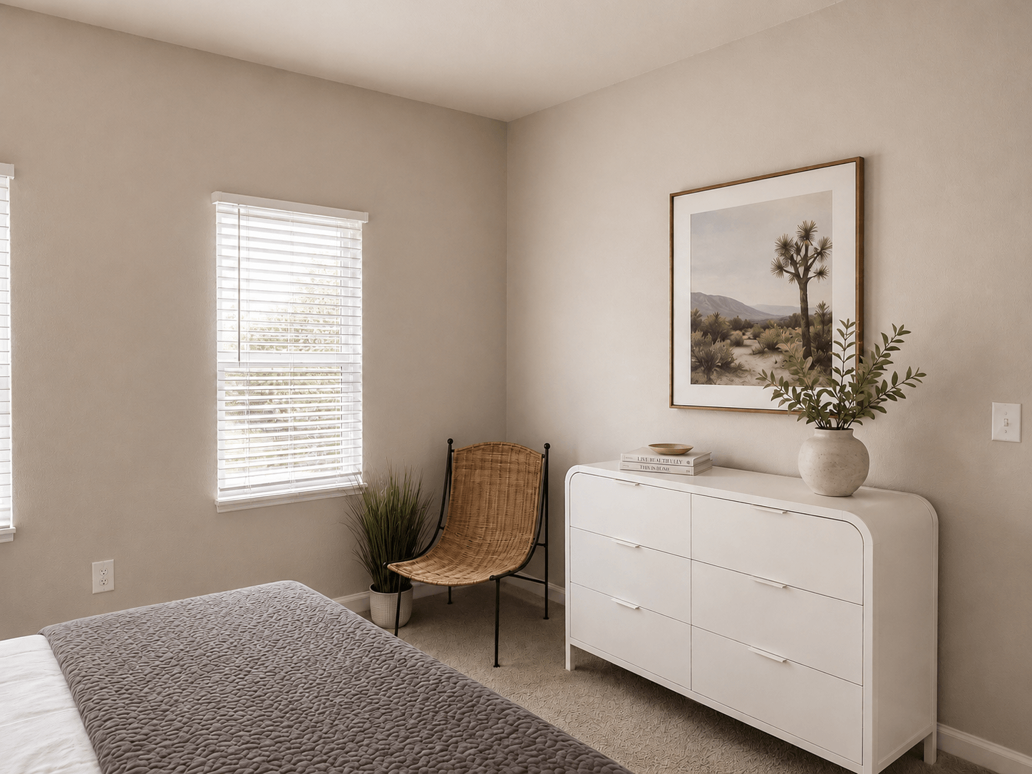 A bedroom with a bed, a chair, a dresser, and a painting on the wall.